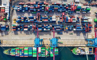 Birds eye view of a ship in a harbor loaded with containers