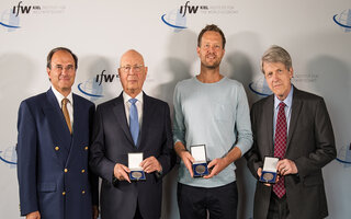 The three winners of the Global Economy Prize 2018 show their medals, Dennis J. Snower joins them for the picture