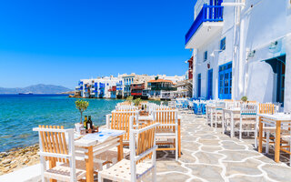 Chairs with tables in typical Greek tavern in Little Venice part of Mykonos town, Mykonos island, Greece