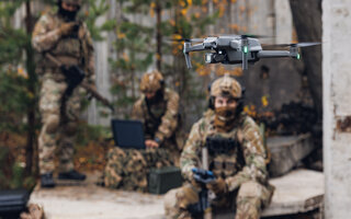 Military soldier controls drone for reconnaissance operation of enemy positions
