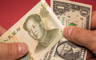 One Chinese yuan and One US dollar banknotes held in hand