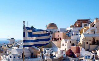 Greece flag in front of houses on a Greek Island