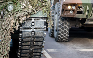 NATO response force or North Atlantic Treaty Organization armored crawler tanks and other military vehicles on the road, close up