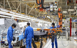 Arbeiter, die Autos auf der Montagelinie von Shanghai Volkswagen installieren und installieren, sind beschäftigt / Workers who install and install cars on the Shanghai Volkswagen factory assembly line are busy