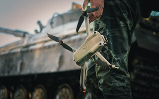 artillery spotter or military observer launches drone into sky force reconnaissance in enemy territory. drone control panel is in hand of military soldier