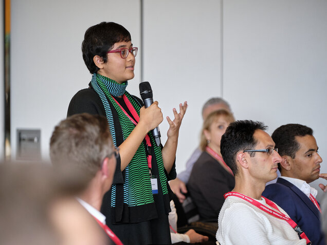 Woman in audience poses question
