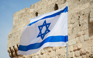 flag of Israel against the sky and the wall