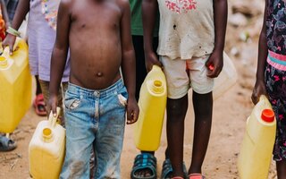 Children carrrying water cans in Uganda Africa