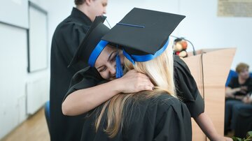 Graduation Zwei junge Frauen umarmen sich bei ihrer Graduierung