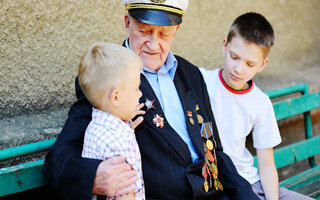 WWII veteran with children. Grandchildren looking at grandfather