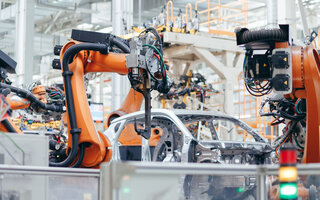 Automated Robot Arm Assembly Line Manufacturing. Modern Electric Car Smart Factory.