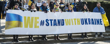 Demonstration, people holding banner saying "We stand with Ukraine"