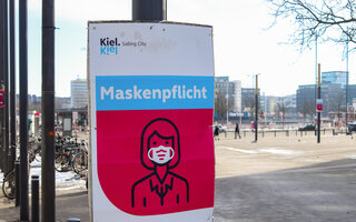 Deutsches Zeichen während Corona-Virus sagt, eine Gesichtsmaske zum Schutz zu tragen / German sign in Kiel during corona virus telling to wear a face mask for protection