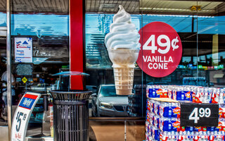 2018_06_09_Tulsa USA Glass Front of convience store with reflections trash can stack of bottled water and giant ice cream cone sign