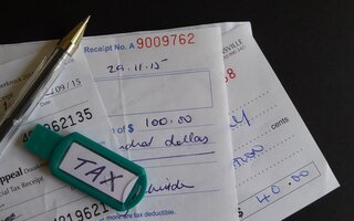 Stash of receipts with pen and USB flash drive