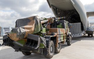 Artillery truck in front of the loading door of an Airbus A400M military transport plane on display at the Paris Air Show 2017