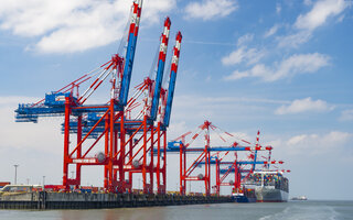 Gantry cranes unload a container ship on the Jade Weser in Wilhelmshaven, Lower Saxony
