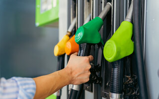 a close-up image of a woman's hands on fuel fuller at a gas station