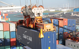 Containerhafen, ein Container wird von Kran transportiert
